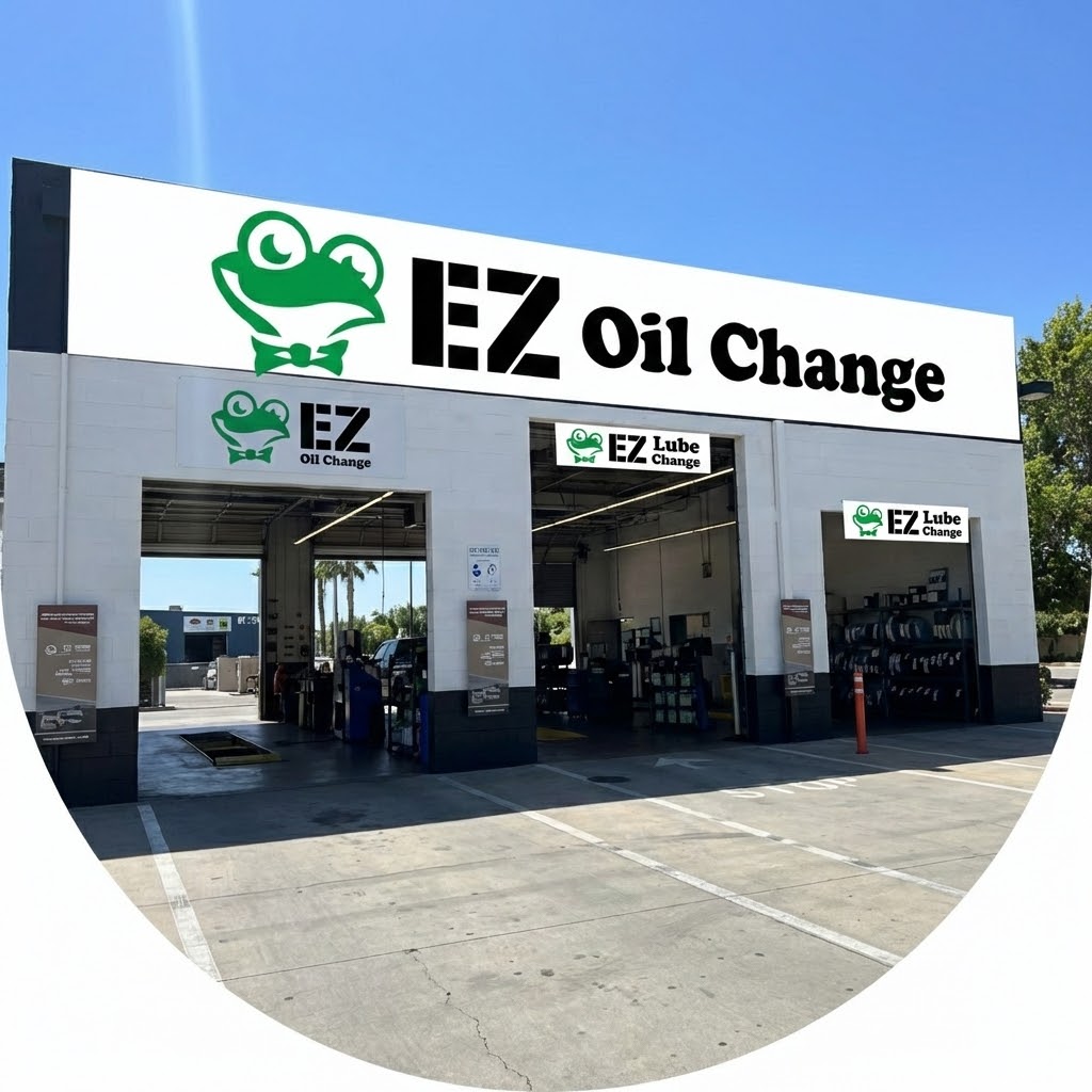 Exterior of EZ Lube Oil Change service station with green frog logo signage and three drive-thru bays.